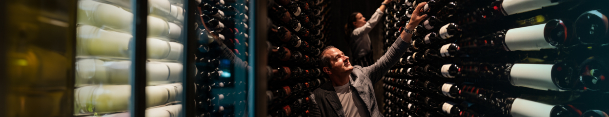 Viron Rondo going through collection of wine bottles in restaurant