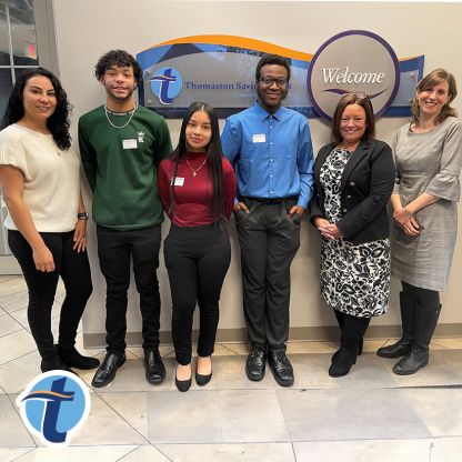 Banking professionals and Waterbury Promise students pose for a photo in a Thomaston Savings Bank lobby.