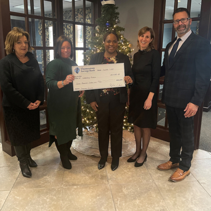 Thomaston Savings Bank executives and Waterbury Promise executives hold a big check granted by the bank.